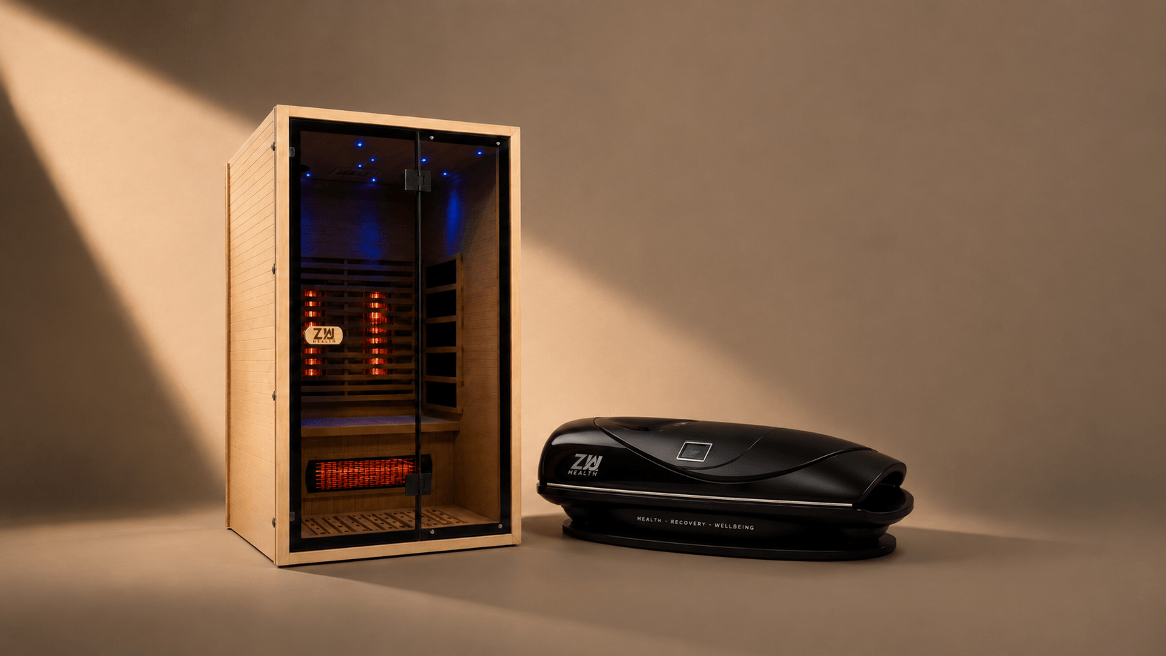 A Zua 2 person infrared sauna and a black Zua Z7 red light bed in a warm studio, lit by a shaft of daylight